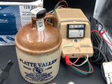 a brown jug sitting on a table next to a meter