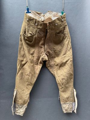 un vieux pantalon suspendu à une corde à linge fixée au mur