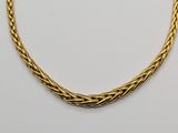 a gold necklace with a braid design on a white background