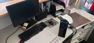un bureau sur lequel se trouvent un ordinateur, un clavier, une souris et d'autres objets