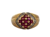 a close up of a gold ring with a ruby and diamond center