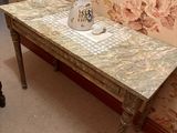 une table sur laquelle est posé un vase, devant un miroir