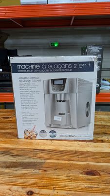 La cafetière se trouve dans la boîte posée sur la table.