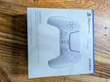 packaging of a white wii controller sitting on top of a wooden table