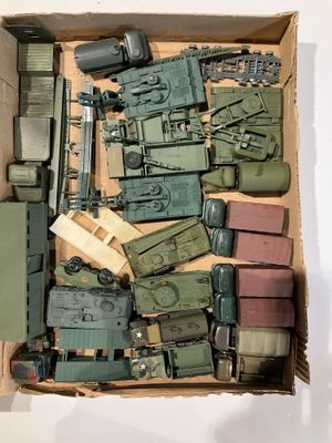 une boîte remplie de véhicules militaires miniatures et d'autres objets