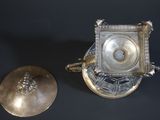 a silver clock sitting next to a silver plate