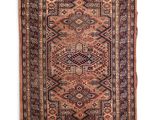 un tapis persan ancien aux motifs géométriques et aux franges