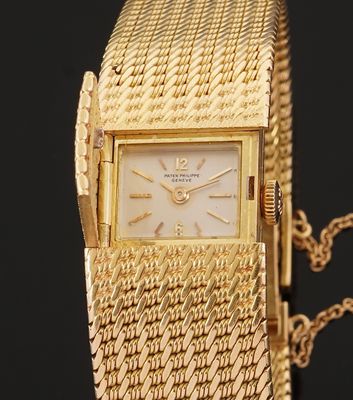 an image of a gold wrist watch with a chain around it