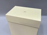 a white box sitting on top of a table next to a gray wall