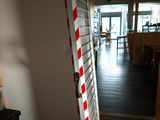 une échelle rayée de rouge et de blanc appuyée contre un mur