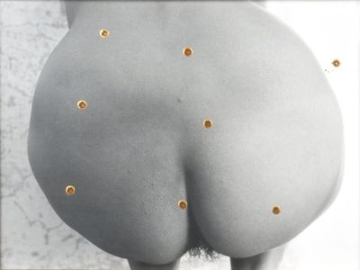 une photo des fesses d'une femme ornées de clous dorés
