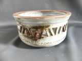 a white bowl with a brown rim on a gray surface