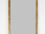 une image d'un miroir encadré d'or sur un mur blanc