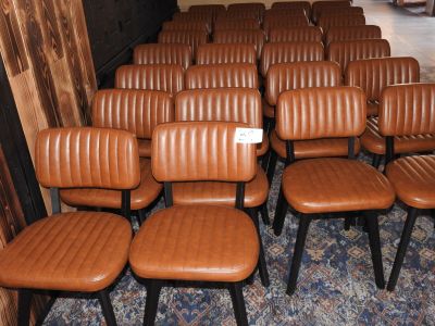 Plusieurs fauteuils en cuir marron sont alignés en rangée dans une pièce