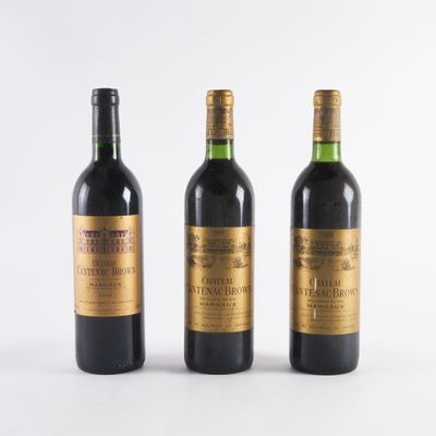 trois bouteilles de vin posées les unes à côté des autres sur une surface blanche