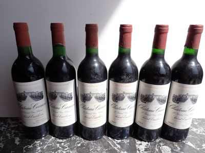 six bottles of wine are lined up on a table