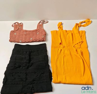 trois vêtements posés sur une table blanche