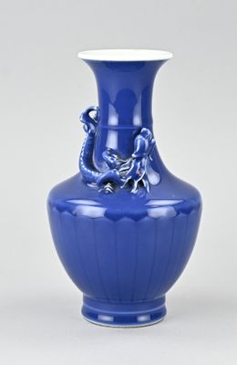 un vase bleu orné d'un dragon sur fond blanc