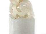 une photo d'un morceau de jade blanc sur lequel est sculpté un animal