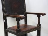 a wooden chair with a leather seat on a white background