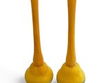 pair of yellow vases sitting on top of each other on a white surface