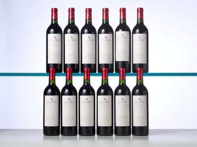 six bottles of red wine are lined up on a shelf