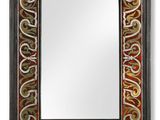 a black and red mirror with a decorative design on it