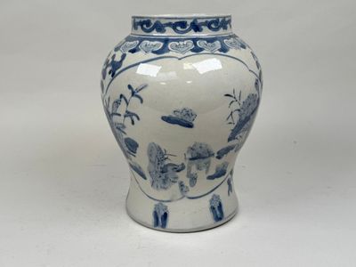 un vase bleu et blanc posé sur une surface blanche