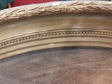 a close up of a gold plate with a red chair in the background