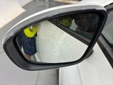 a reflection of a person in the side view mirror of a car