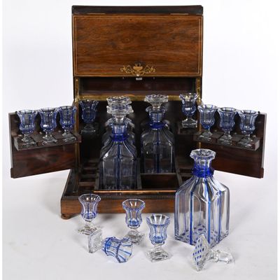 bottles and glasses in a wooden case on a white surface