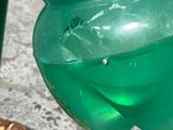 a close up of a green water fountain on a sidewalk