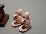 a small figurine of a mouse and a pair of flip flops