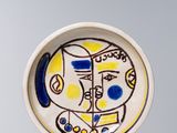 une photo d'une assiette décorée d'une peinture, posée sur une table