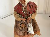 a figurine of an old woman with a basket of flowers