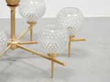five glass vases on a gold stand on the floor