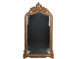 un miroir au cadre doré ouvragé sur fond blanc
