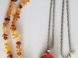 a necklace with a red glass bead and a silver chain