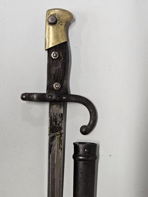un couteau accroché au mur à côté d'une bouteille