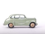 a green toy car that is sitting on a white surface