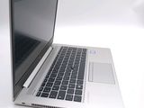 a silver laptop with a black keyboard on a white surface