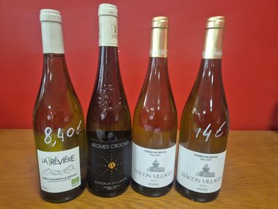 quatre bouteilles de vin sont alignées sur une table en bois