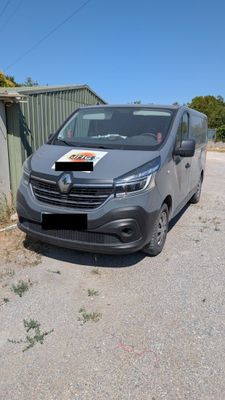 La camionnette est garée sur le bord de la route, devant un immeuble.