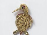 an image of a gold bird broochle with ruby eyes