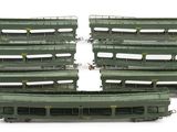 six green train cars sitting next to each other on a white surface