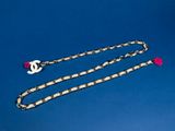 a chain with a pink heart on it on a blue background