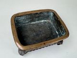 a small metal bowl sitting on a white surface