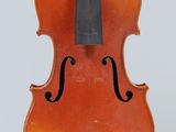 un vieux violon posé sur un chevalet, sur une surface blanche