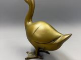 brass duck figurine on a white background