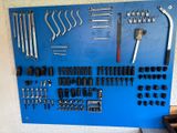 a blue board with a bunch of tools hanging on it